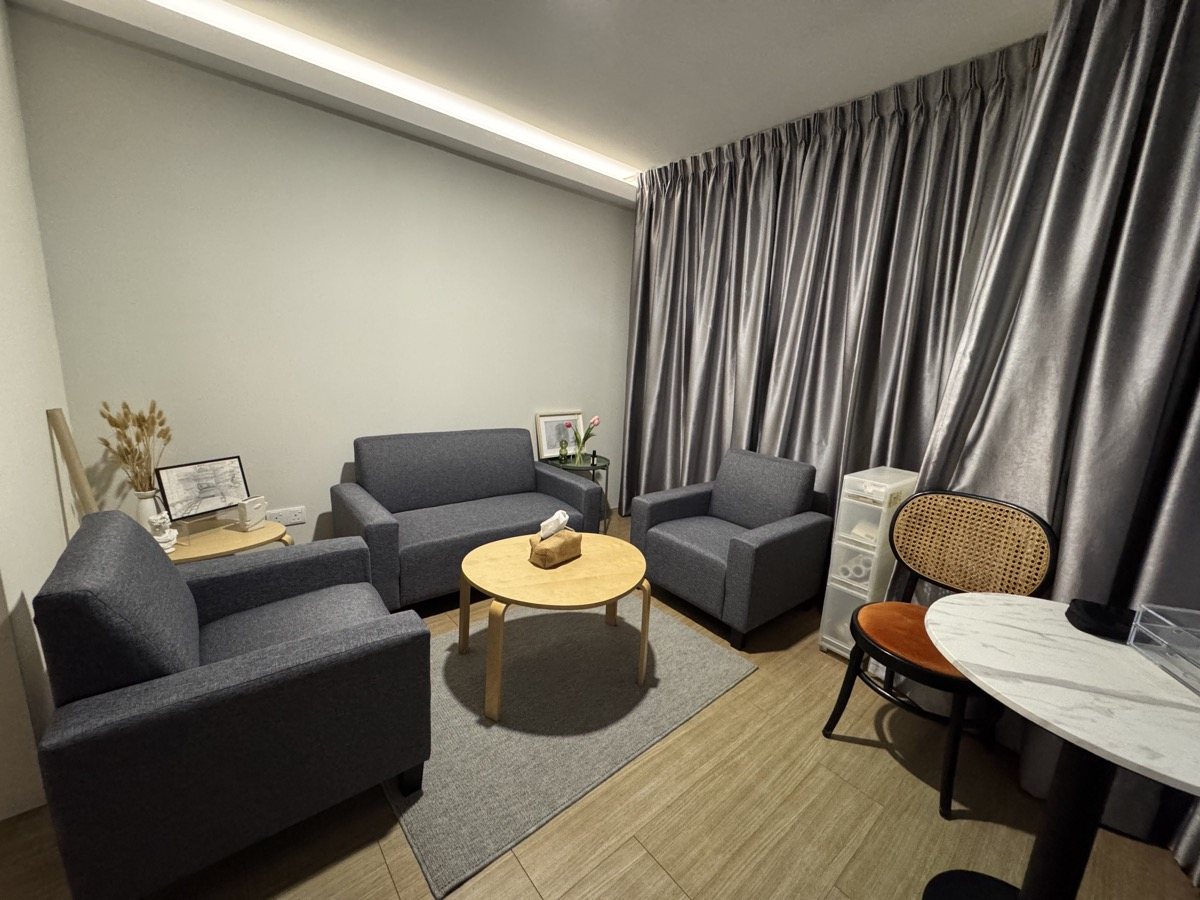 Comfortable counselling room with grey seating and a round table