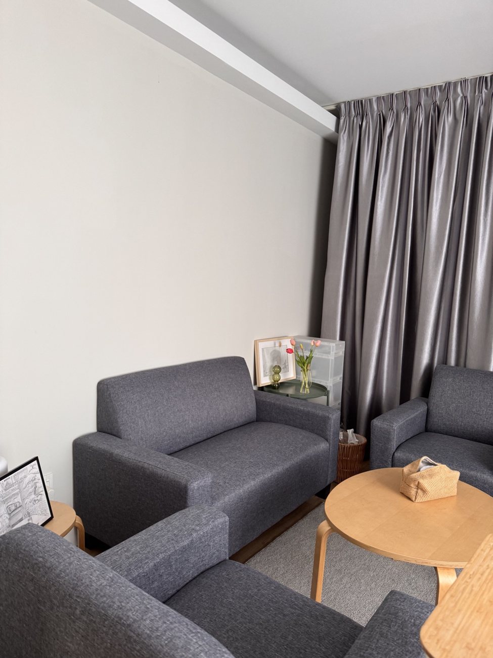 Therapy room seating with warm wood and soft curtains